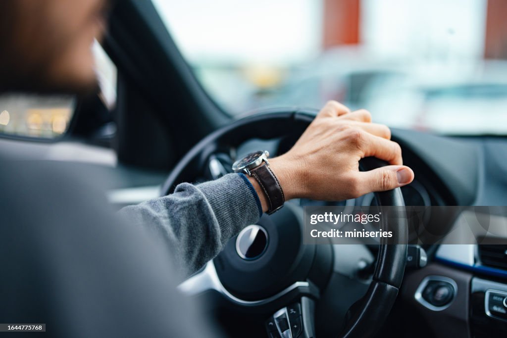 Um empresário irreconhecível dirigindo seu carro