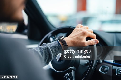 Um empresário irreconhecível dirigindo seu carro Um empresário irreconhecível dirigindo seu carro