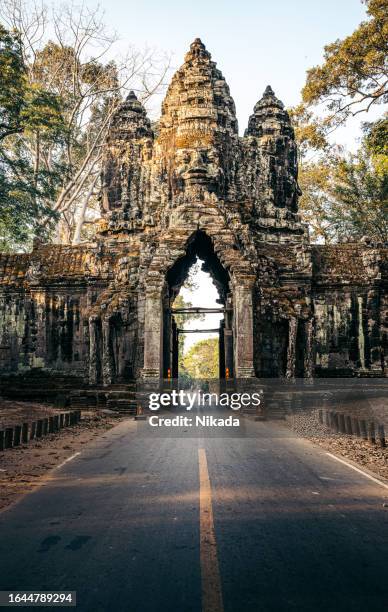 straße, die durch das nordtor von angkor thom, kambodscha führt - angkor wat stock-fotos und bilder