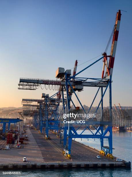Giant gantry cranes lined up in Haifa container port, Israel, at sunrise.