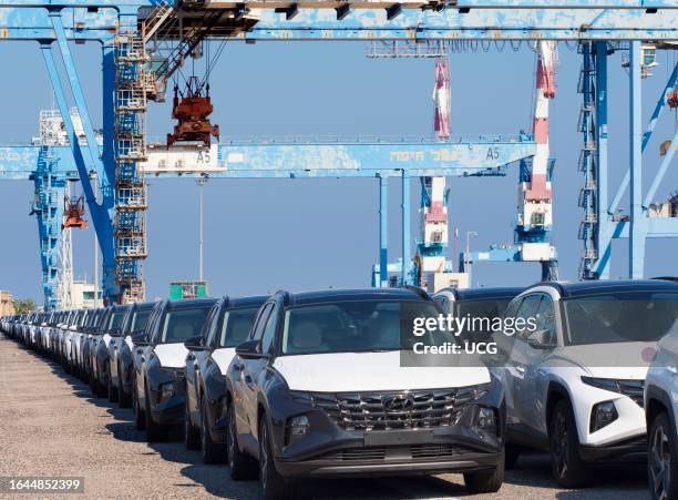 Parked imported cars and gantry cranes on the quayside at Haifa container port, Israel.