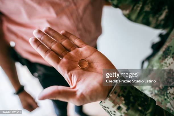 close-up of a soldier holding a wedding ring - military divorce stock pictures, royalty-free photos & images