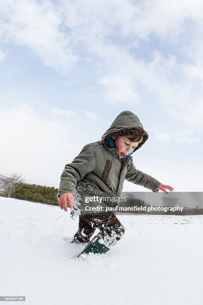 Young boy stepping his way through snow