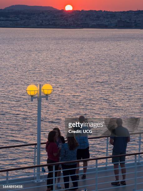 Chatting on deck, cruise liner moored departing Limassol, Cyprus, at sunset.