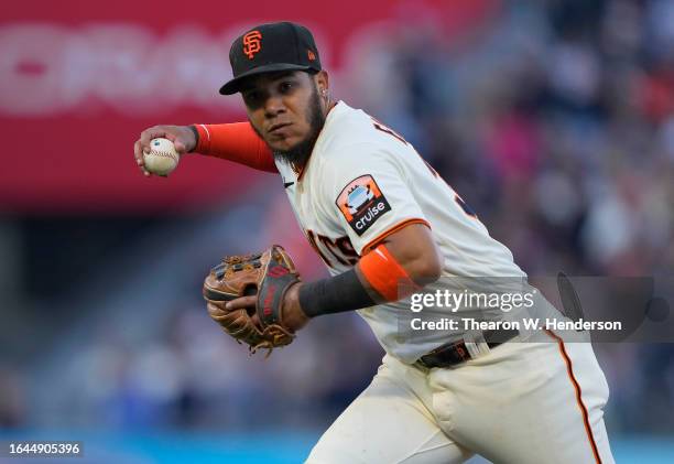 Thairo Estrada of the San Francisco Giants throws off balance to first base throwing out Matt Olson of the Atlanta Braves in the top of the seventh...
