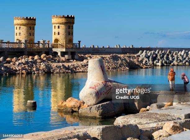 Relaxing by the breakwater and Citadel of Qaitbay in Alexandria, Egypt.