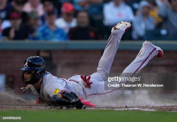 Orlando Arcia of the Atlanta Braves dives at home plate against the San Francisco Giants in the top of the fifth inning at Oracle Park on August 27,...