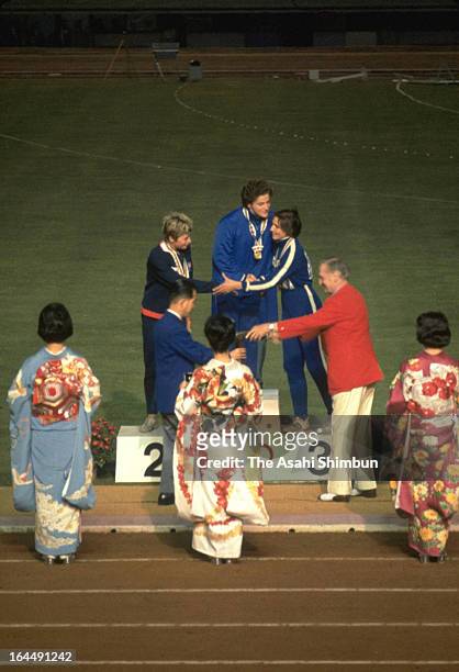 Gold Medalist Irina Press of Soviet Union, Silver medalist Mary Rand of Great Britain and Galina Bystrova of Soviet Union are seen on the podium...