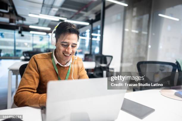 mid adult man working on a call center in the office - ver stockfoto's en -beelden