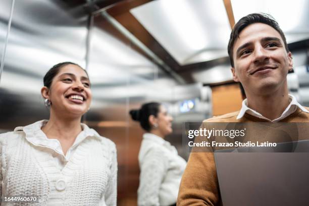 coworkers talking in the elevator - man inside elevator stock pictures, royalty-free photos & images