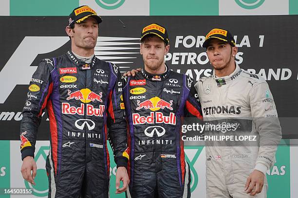 Red Bull driver Sebastian Vettel of Germany stands on the podium along with second-placed Red Bull driver Mark Webber of Australia and third-placed...