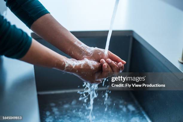 frau wäscht sich die hände, um keime abzutöten - washing hands stock-fotos und bilder