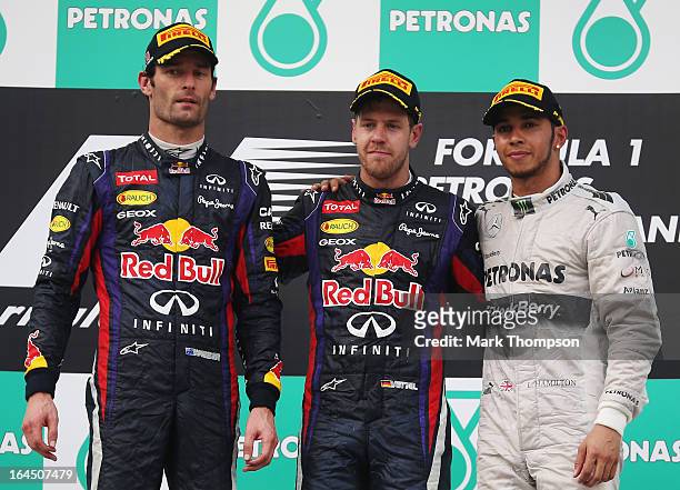 Race winner Sebastian Vettel of Germany and Infiniti Red Bull Racing, second placed Mark Webber of Australia and Infiniti Red Bull Racing and third...