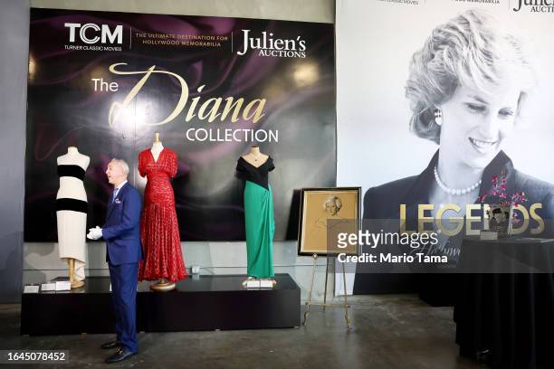 Martin Nolan, executive director of Julien's Auctions, speaks in front of gowns owned by Princess Diana on display during a media preview of...