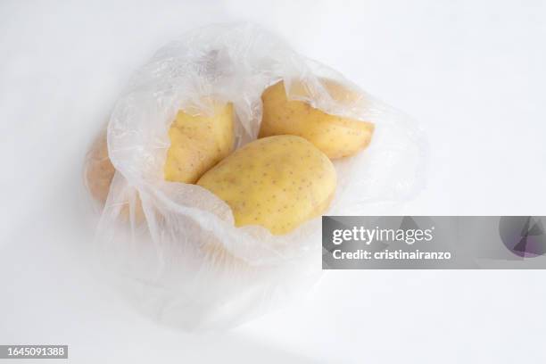 potatos packed in plastic bag - cristinairanzo stock pictures, royalty-free photos & images