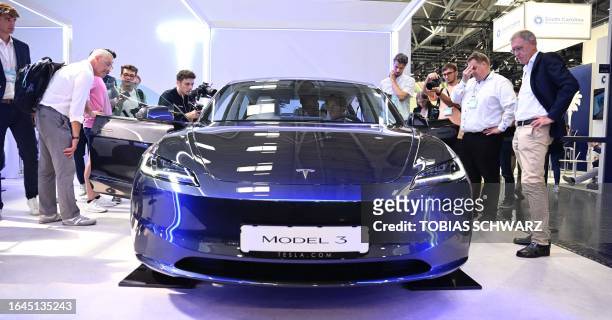Visitors inspect a Tesla model 3 car on display at the International Motor Show in Munich, southern Germany, on September 4, 2023. Germany's IAA...