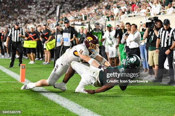 Michigan State Spartans tight end Maliq Carr holds onto a touchdown reception as he's knocked to the ground by Central Michigan Chippewas linebacker...