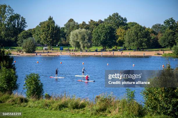 September 2023, Bremen: Stand-up paddlers and swimmers at Lake Werder. This week it is supposed to get warm once again in Lower Saxony and Bremen....