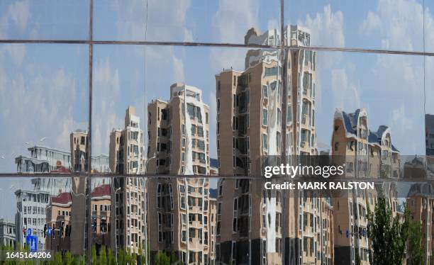 Empty apartment buildings are reflected in a window in the city of Ordos, Inner Mongolia on September 12, 2011. The city which is commonly referred...