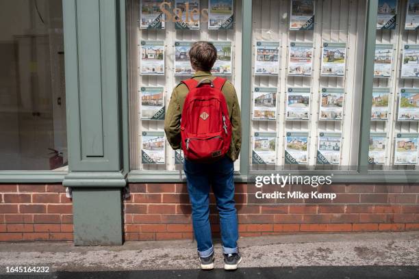 Woman looking in the window of an estate agent in Kings Heath on 6th August 2023 in Birmingham, United Kingdom. Housing in Birmingham is a very...