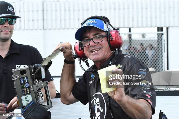 Team Track Specialist Lanny Miglizzi reads the timing slip from the Robert Hight John Force Racing Chevrolet Camaro SS NHRA Funny Car win in the...