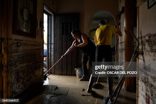 Residents clean mud in their house in the town of Villamanta, in the Madrid region on September 4 At least three people died and another three were...