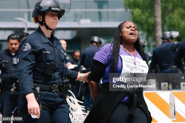 Los Angeles, CA A police officer arrests Keisha Stewart during a demonstration with thousands of healthcare workers to call for the urgent need for...