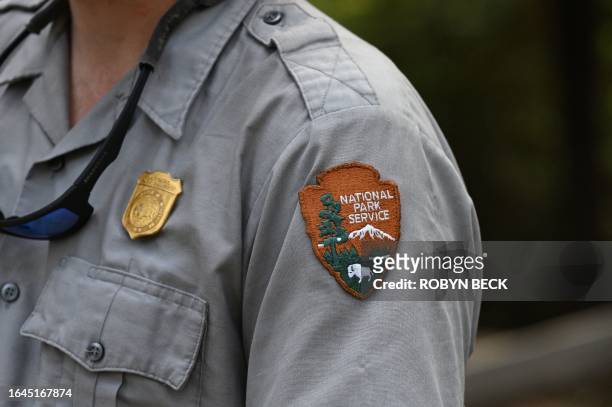 The National Park Service badge is seen on a staff member's uniform during a media visit to the in the Giant Sequoia tree and mixed conifer forest of...