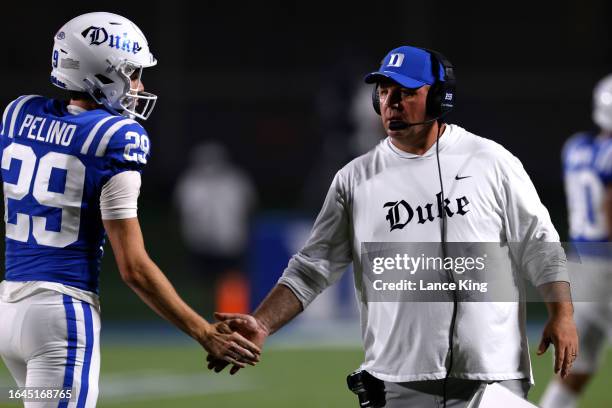 Head coach Mike Elko of the Duke Blue Devils congratulates Todd Pelino following his field goal against the Clemson Tigers during the first half of...