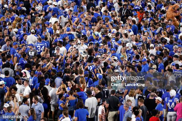 Players and fans of the Duke Blue Devils celebrate on the field following the game against the Clemson Tigers at Wallace Wade Stadium on September 4,...