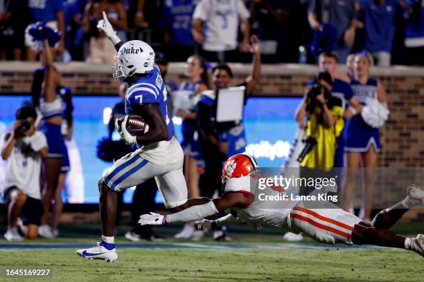 Jordan Waters of the Duke Blue Devils runs for a touchdown while avoiding a tackle by R.J. Mickens of the Clemson Tigers during the second half of...