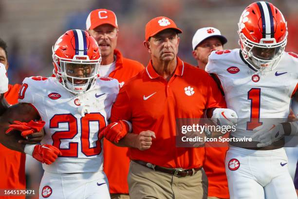 Head Coach Dabo Swinney of the Clemson Tigers walks arm in arm with his players before a football game against the Duke Blue Devils at Wallace Wade...