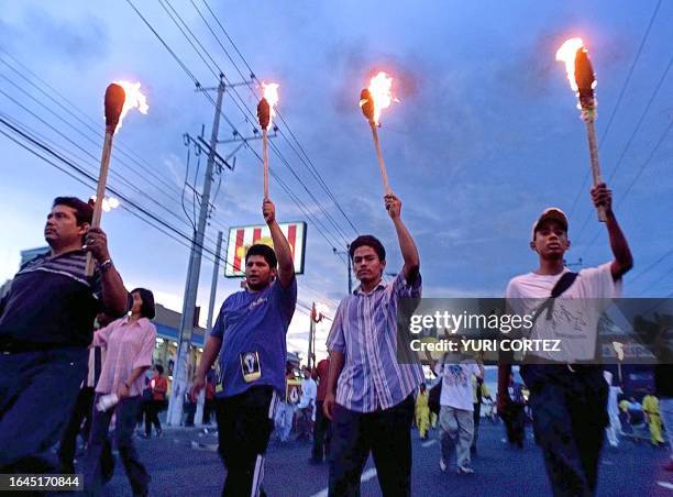 Group of people carrying torches, demonstrate, 13 July 2001, during a protest against President Francisco Flores demanding that the government...