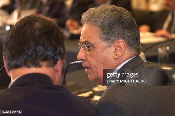 Brazilian President Fernando Henrique Cardoso speaks with Economic Minister Pedro Malan at the Mercosur summit 08 December 1999 in Montevideo. El...