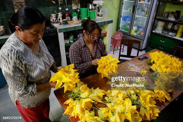 Dona Luci Padron and Yamileth Ortega Padron, mother and daughter respectively, make bunches of squash flowers for sale in Tlahuac City Hall, Mexico...