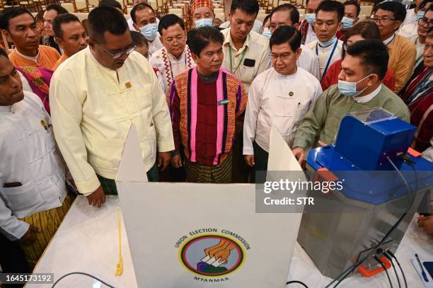 Members of Myanmar's Union Election Commission speak during a demonstration of voting machines to be used in future elections in Yangon on September...