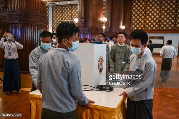 Members of Myanmar's Union Election Commission prepare for a demonstration of voting machines to be used in future elections in Yangon on September...