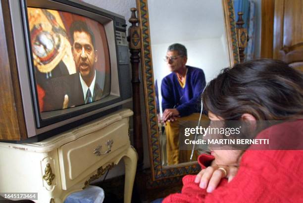 Middle class family watches the President of Ecuador, Lucio Gutiérrez on television in Quito, Ecuador 19 January 2003. Una familia de clase media...