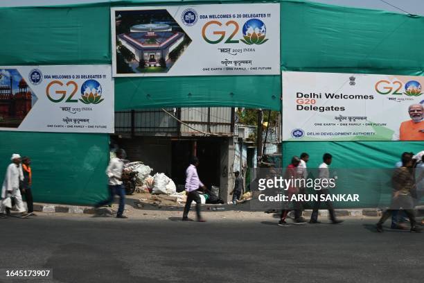 People walk past G20 India summit hoardings along a street in New Delhi on September 5 ahead of its commencement.