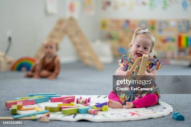 little girl with down syndrome playing - down syndrome baby stock pictures, royalty-free photos & images