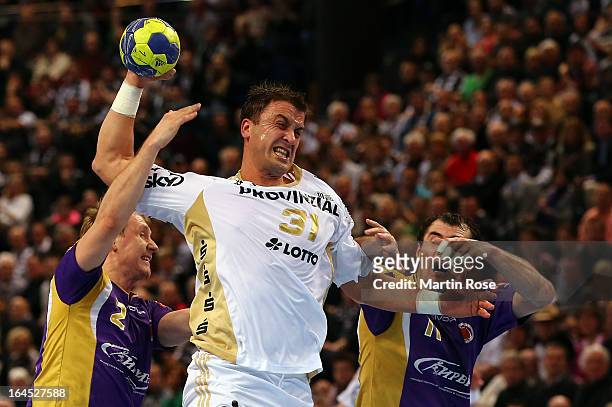 Momir Ilic of Kiel challenges Vasily Filippov and Sergiy Shelmenko of Medvedi for the ball during the EHF Champions League second leg round of...