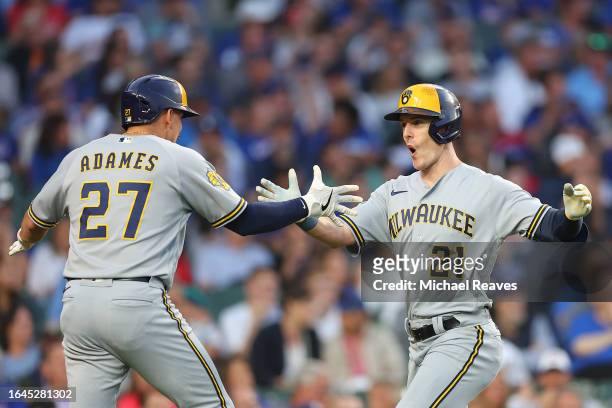 Mark Canha of the Milwaukee Brewers celebrates with Willy Adames after hitting a two-run home run off Jameson Taillon of the Chicago Cubs during the...