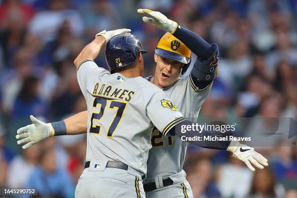 Mark Canha of the Milwaukee Brewers celebrates with Willy Adames after hitting a two-run home run off Jameson Taillon of the Chicago Cubs during the...