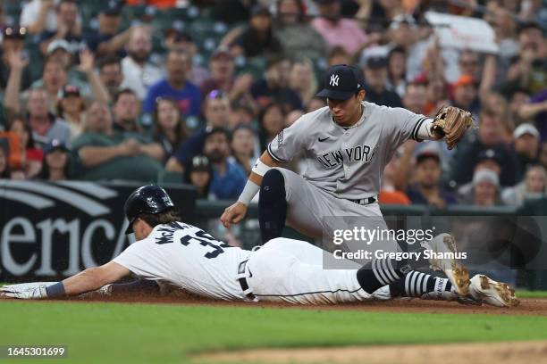 Zach McKinstry of the Detroit Tigers slides in safely for a sixth inning triple past the tag of Oswaldo Cabrera of the New York Yankees at Comerica...