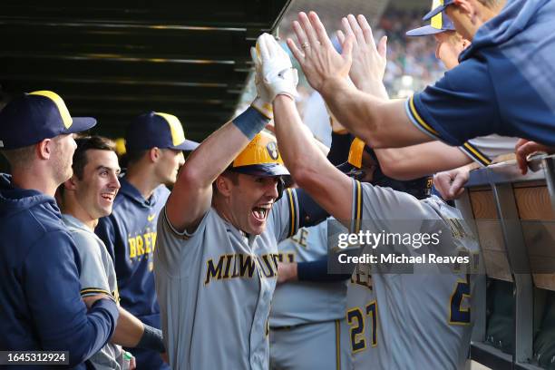 Mark Canha of the Milwaukee Brewers celebrates with Willy Adames after hitting a two-run home run off Jameson Taillon of the Chicago Cubs during the...