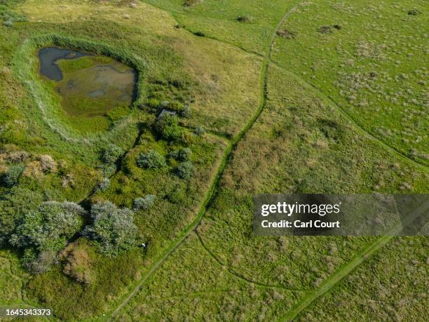 Walking trails cross Longis Common, believed to be the site of mass graves for prisoners executed or worked to death by the Nazis while being used as...