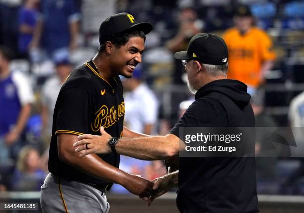 Johan Oviedo of the Pittsburgh Pirates celebrates his complete-game shutout against the Kansas City Royals with manager Derek Shelton of the...