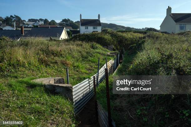 Houses overlook a German World War II trench system on September 3, 2023 in Alderney, Guernsey. This year, the British government is expected to...