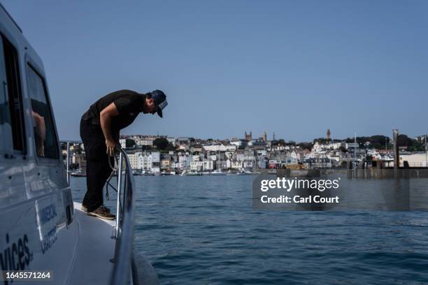 Crew member on board the Alderney to Guernsey ferry prepares for arrival in Saint Peter Port on September 5, 2023 in Guernsey. This year, the British...