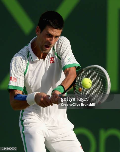 Novak Djokovic of Serbia plays a backhand against Somdev Devvarman of India during their third round match at the Sony Open at Crandon Park Tennis...